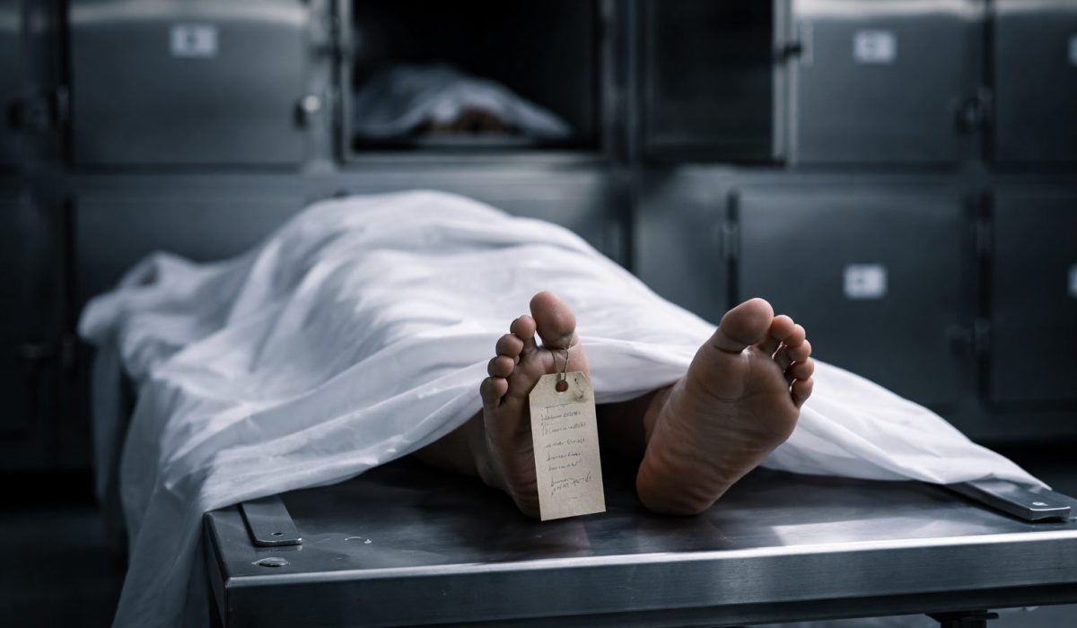 Corps recouvert d’un drap sur une table de morgue dans une chambre froide mortuaire